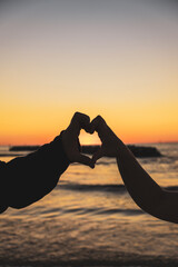 silhouette of a man and woman hands on the beach