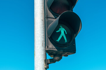 Green light, pedestrian stop light closeup on the street