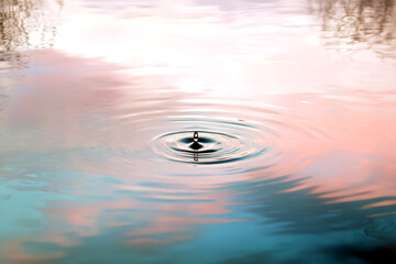 Water drop creating ripples and reflection, peaceful scene, abstract textures, artistic, serene, tranquil and minimalistic