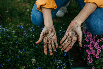 Gardener showing dirty hands after planting flowers