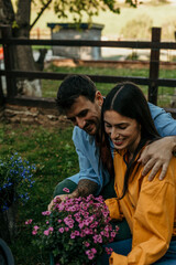 Happy couple gardening together, taking care of flowers in their garden