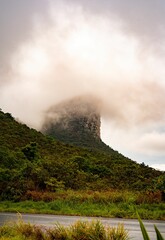 Fototapeta premium Mountain peak enveloped in mist with lush greenery.
