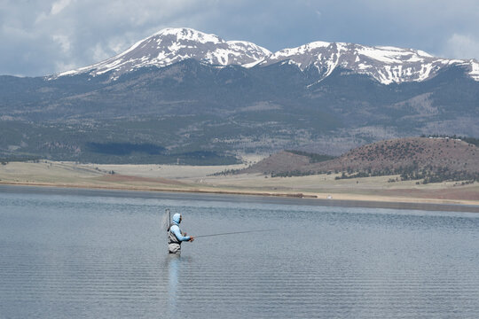 Man Flyfishes in Colorado with Mountains in background