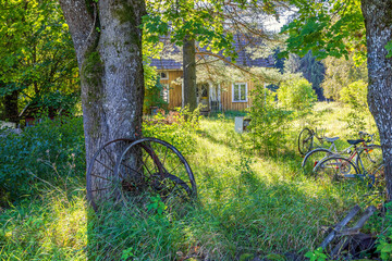House in overgrown garden with old bicycles in the countryside © Lars Johansson