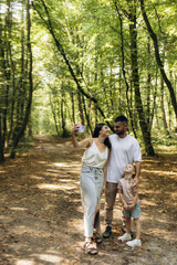 Fototapeta premium Family Enjoying a Relaxing Walk in a Vibrant Forest Setting