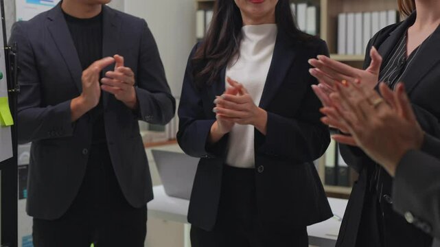 Professional business team clapping hands, celebrating collaborative success and expressing genuine workplace appreciation during team meeting