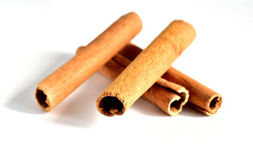 Dry sticks of aromatic cinnamon spice lie on a white background