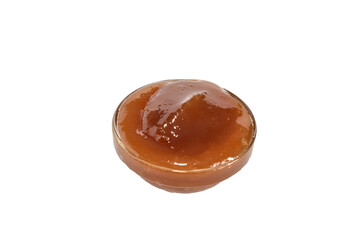 Thick dark honey in a round plate, which stands on a white background.