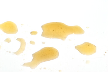 Drops of spilled marinade from mushrooms on a white background.