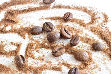 Ground coffee and whole beans lie on a white background.