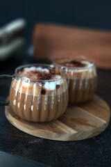 two steaming cups of frothy cappuccino on a wooden platter, with soft lighting creating a cozy, warm atmosphere against a dark background, perfect for a relaxed coffee break. mug, sipping, home