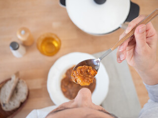 Woman eating lentil stew with a spoon at lunch