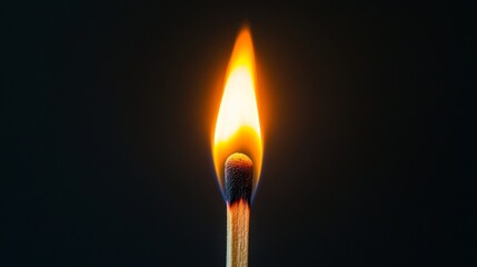 A burning matchstick with a bright flame against a dark background