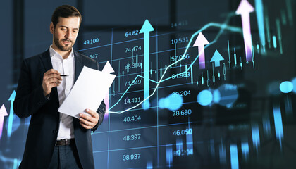 Businessman analyzing financial report with stock market graph background.