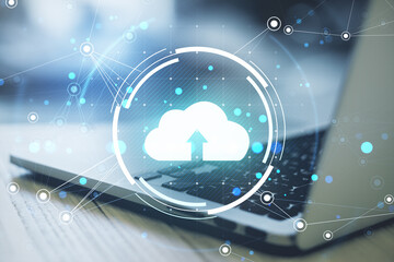 Cloud computing technology concept with a glowing upload icon over a laptop keyboard.