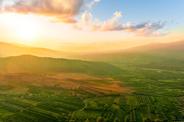 rustic landscape view of rural green valley in mountain hills with farms and gardens