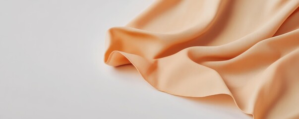 clean apron mockup concept. Soft, flowing fabric in a warm peach color on a smooth surface.