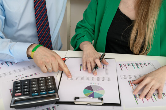 Wsp&oacute;łpracownicy w korporacji analizujący bilans zysk&oacute;w i strat, kobieta i mężczyzna pracujący razem w biurze 