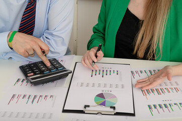 Praca w finansach, ksiegowi siedzą przy biurku i liczą