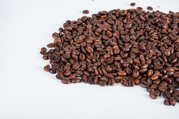 Obraz premium Pile roasted coffee beans isolated on a white background.