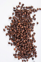 Pile roasted coffee beans isolated on a white background.