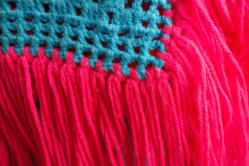 Textured a vibrant blue and pink crocheted or knitted fabric.