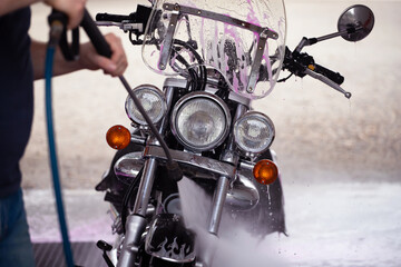 Washing a motorcycle with cleaning foam at a car wash.