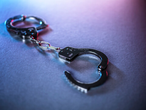 Open handcuffs on a surface symbolizing justice and crime
