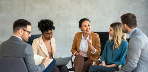 Diverse group of businesspeople discussing charts during a meeting together in a modern office