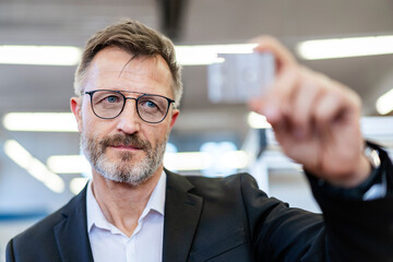 Businessman in a production hall checking a product