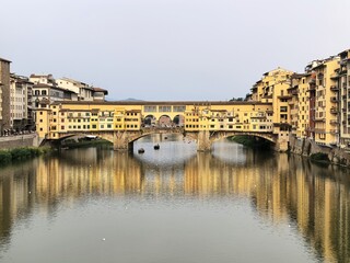 Obraz premium The old bridge bathed in the setting sun, the classical beauty of Florence is fully displayed here