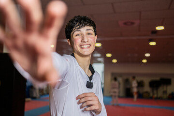 Young martial artist smiling in a dojo wearing a judo uniform
