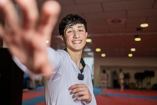 Young martial artist smiling in a dojo wearing a judo uniform