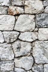 Fototapeta premium Roughly stacked white stone wall texture with weathered surface