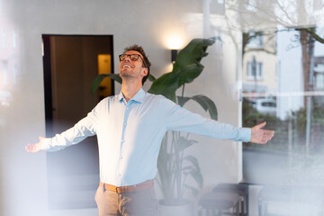 Businessman enjoying freedom and optimism in a caf�