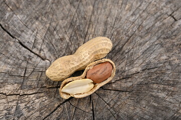 Peanuts on an old wooden board. Whole and shelled nuts.