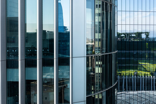 Facade of modern building with white vertical stripes and green reflections in London, combining simplicity, geometry, and sustainable urban views.