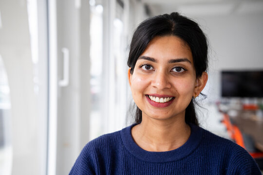Smiling woman in a purple sweater at the office