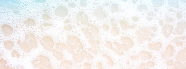 Fototapeta premium White foam waves washing onto light beige sandy beach. Aerial beach image for banner with copy space. Summer vacation and tropical paradise concept.