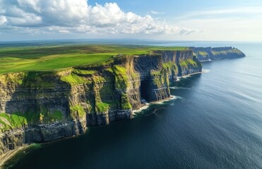 their majestic cliffs and green meadows stretching into the distance, captured from an aerial perspective.