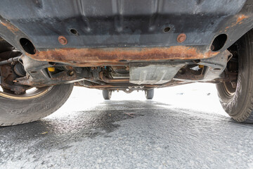 Undercarriage view of 1996  classic American 4x4 pickup truck SUV showing rusty frame, suspension,...