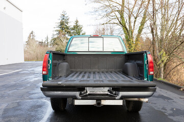  Rear angle of 1996 green 4X4 pickup truck with open tailgate, showing extended cab and empty bed liner in clean condition