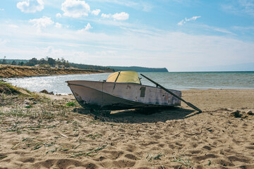 Old paddle boat stands on sand, Baikal lake shore