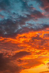 Orange clouds at sunset. Dramatic clouds background vertical photo