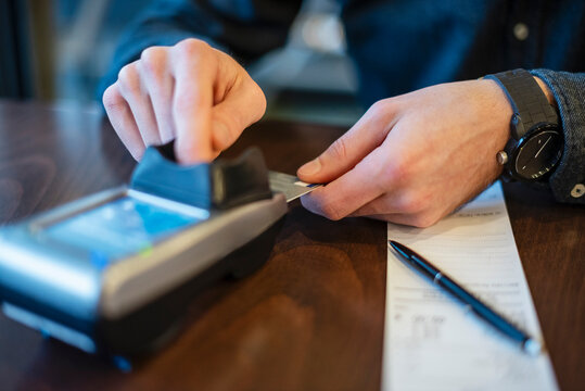 Young man making a payment with a credit card in a business setting