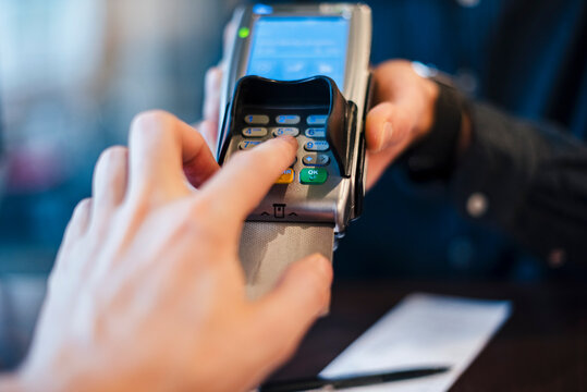 Close-up of a hand using a credit card at a point of sale terminal in a business setting
