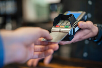 Close-up of hands making a digital payment with a credit card at a point of sale