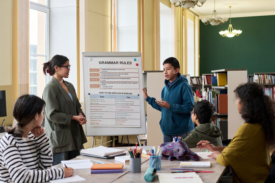 Teenage student presenting grammar rules in a classroom during a language lesson
