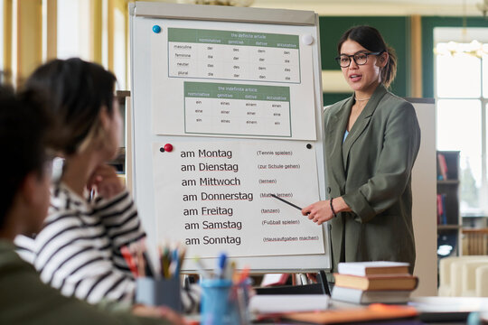 Mentor explaining grammar rules to students at language class