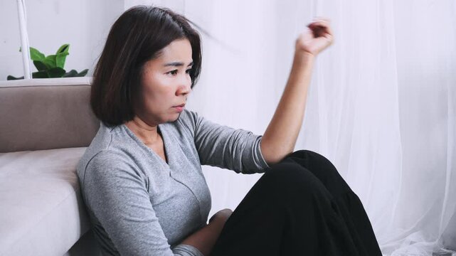 stressed Asian woman  Trichotillomania or hair pulling habit due to mental health issues, unable to stop pulling hair from her scalp, leading to hair loss and frustration